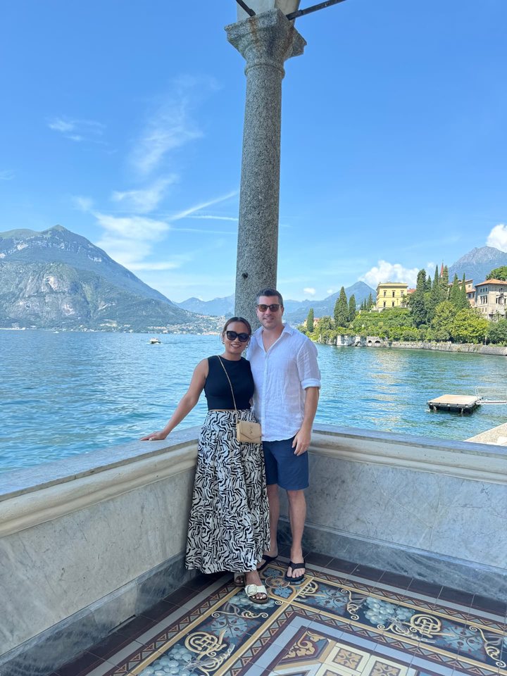 Mark and Charinee standing together by a lake